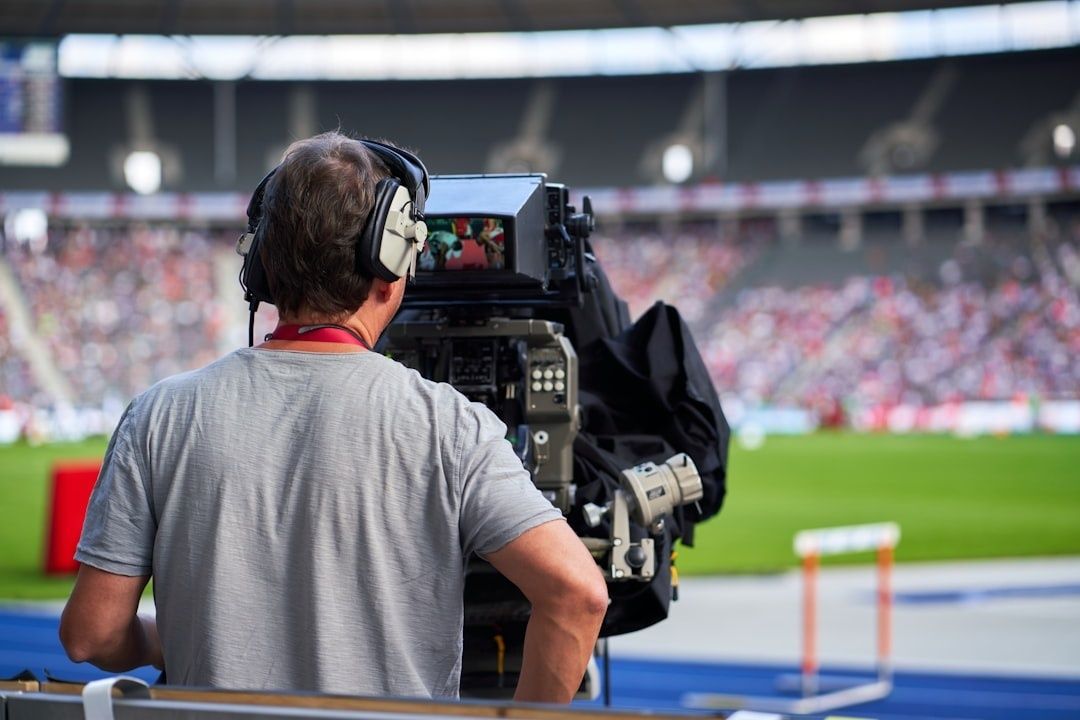 Cameraman filming a football match from the stadium sideline
