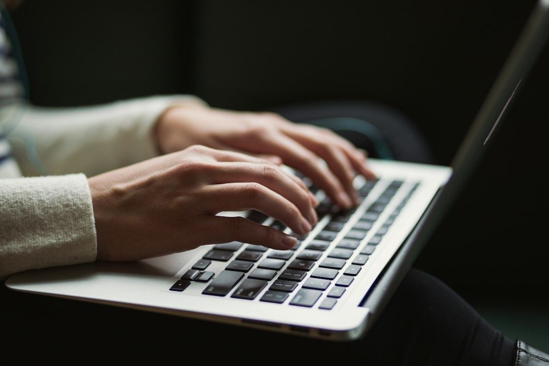 Hands typing on a laptop, illustrating digital investigative research