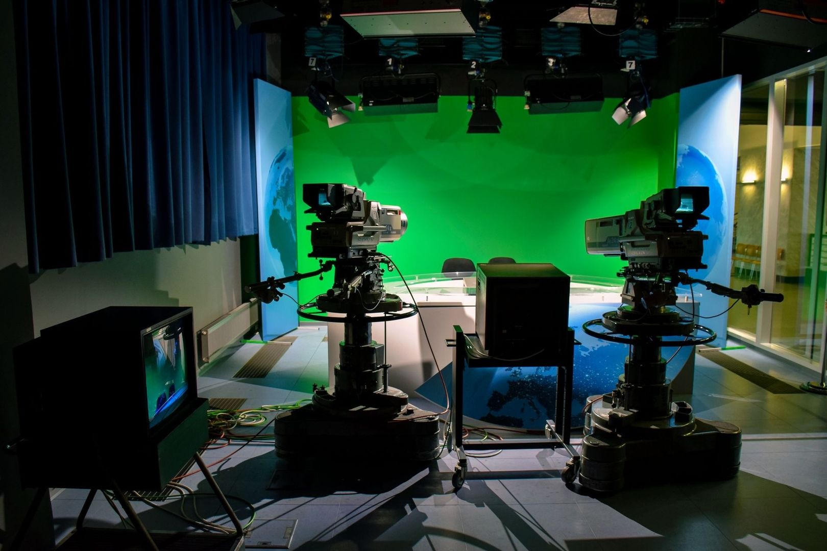Television cameras face a green-screen news studio set